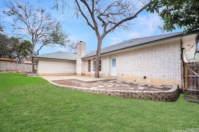 rear view of house featuring a patio area, fence, a lawn, and brick siding