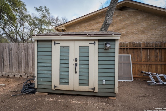 view of shed featuring fence