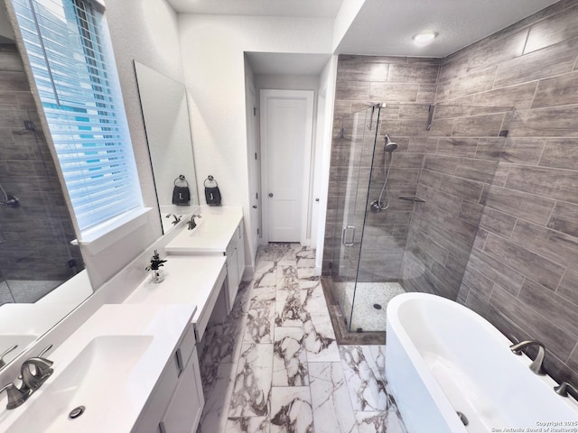 full bath featuring a stall shower, marble finish floor, a freestanding bath, and vanity