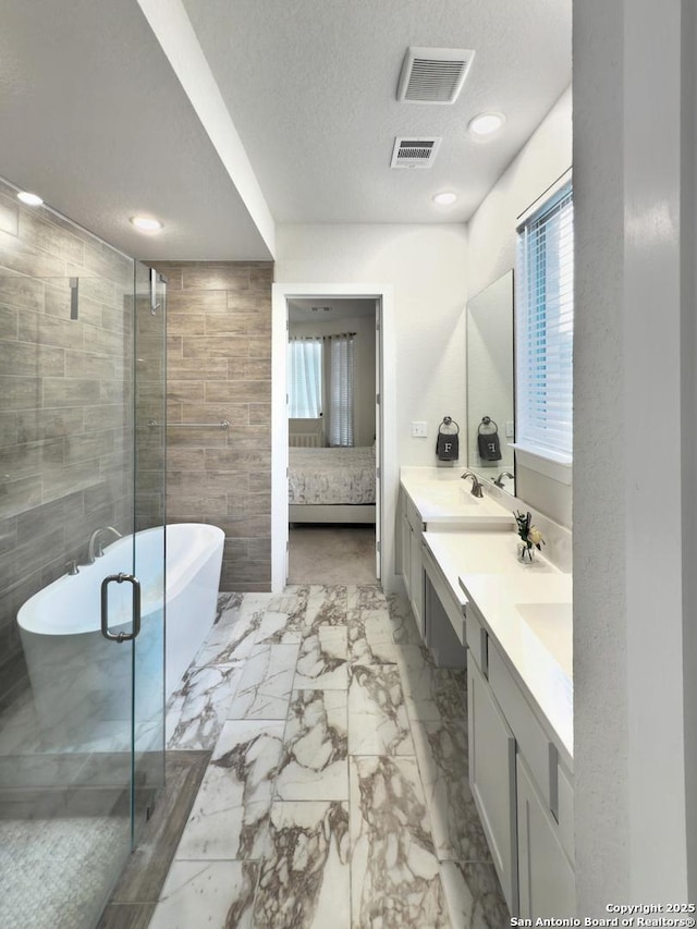 full bathroom with marble finish floor, visible vents, a textured ceiling, and ensuite bath