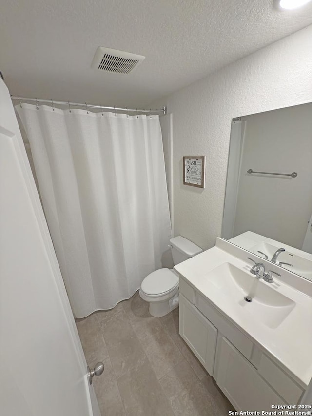 bathroom featuring visible vents, a textured wall, toilet, a textured ceiling, and vanity