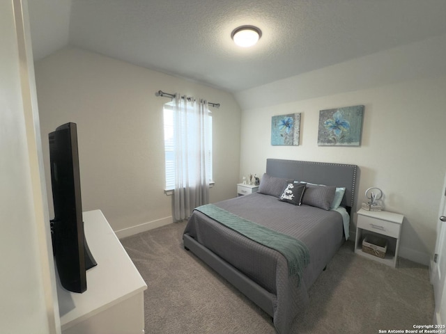 carpeted bedroom featuring lofted ceiling, a textured ceiling, and baseboards