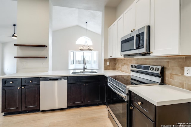 kitchen with a sink, white cabinets, light countertops, appliances with stainless steel finishes, and open shelves