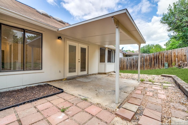 rear view of property featuring french doors, a patio, and fence