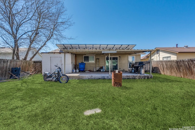 back of property featuring a fenced backyard, a patio, and a lawn