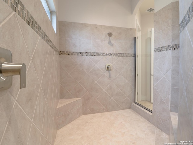 bathroom featuring tiled shower and visible vents