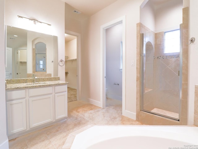 bathroom featuring toilet, a stall shower, vanity, baseboards, and tile patterned floors