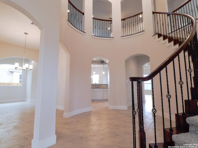 entryway featuring a healthy amount of sunlight, stairs, baseboards, and a towering ceiling