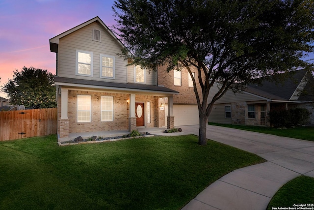 view of front of house featuring a porch, brick siding, fence, driveway, and a front lawn