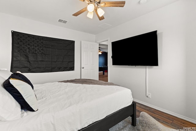 bedroom featuring visible vents, ceiling fan, baseboards, and wood finished floors