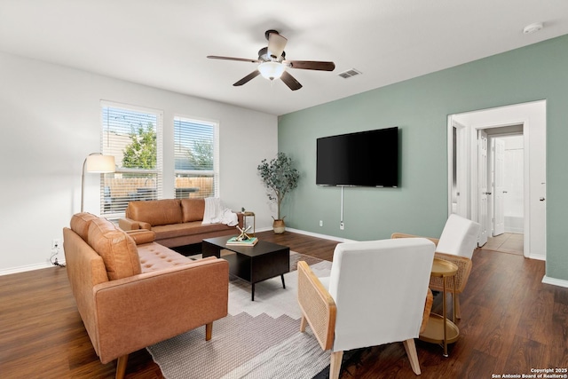 living room with visible vents, ceiling fan, baseboards, and wood finished floors