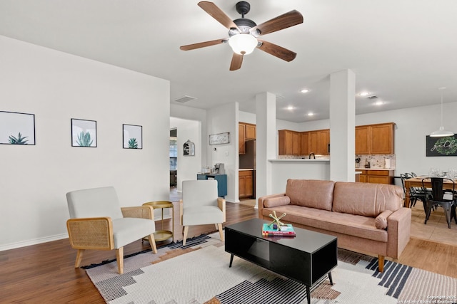 living area featuring baseboards, visible vents, a ceiling fan, light wood-type flooring, and recessed lighting