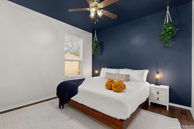 bedroom featuring wood finished floors, a ceiling fan, and baseboards