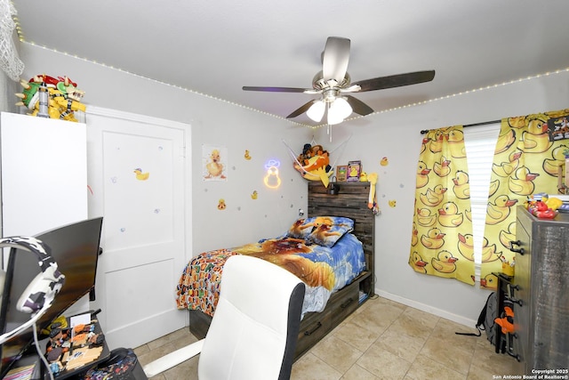 bedroom featuring ceiling fan, baseboards, and light tile patterned flooring