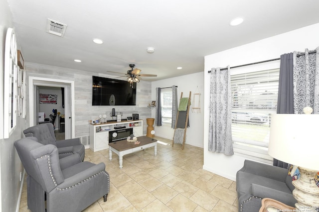 living room featuring an accent wall, visible vents, a ceiling fan, and recessed lighting