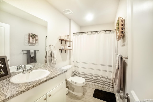 bathroom with curtained shower, visible vents, toilet, vanity, and wood finished floors