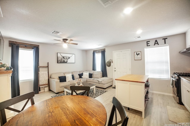 dining space featuring light wood-style floors, ceiling fan, and visible vents