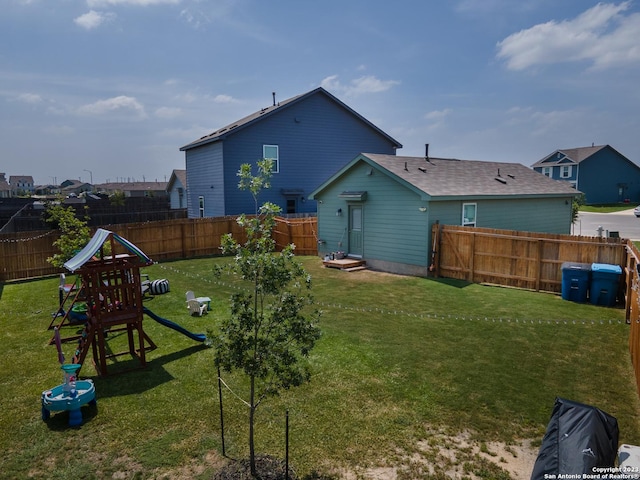 rear view of property featuring entry steps, a fenced backyard, and a yard