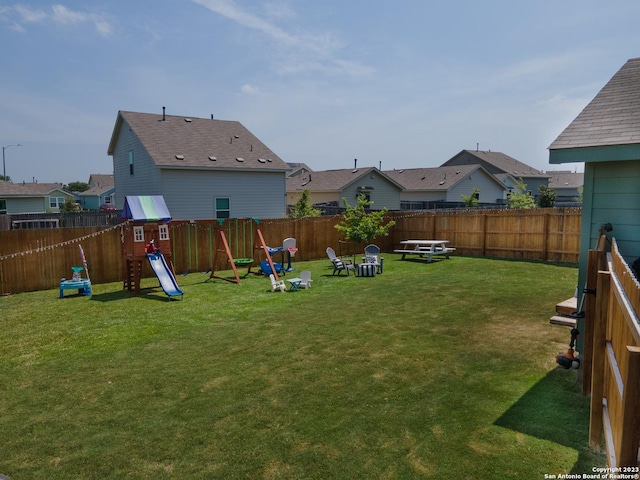 view of yard featuring a residential view, a fenced backyard, and a playground