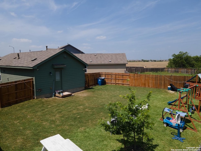 view of yard with a fenced backyard and a playground