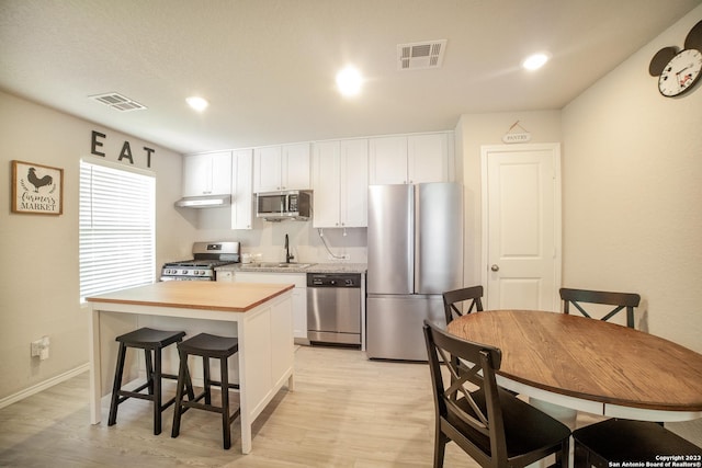 kitchen featuring visible vents, appliances with stainless steel finishes, a sink, and a center island