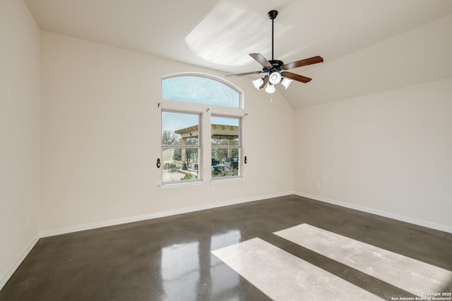 spare room with lofted ceiling, ceiling fan, concrete floors, and baseboards