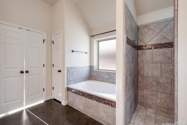 bathroom featuring a garden tub, vaulted ceiling, and tiled shower