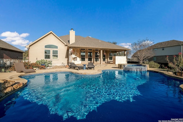 view of pool featuring a patio area and a pool with connected hot tub