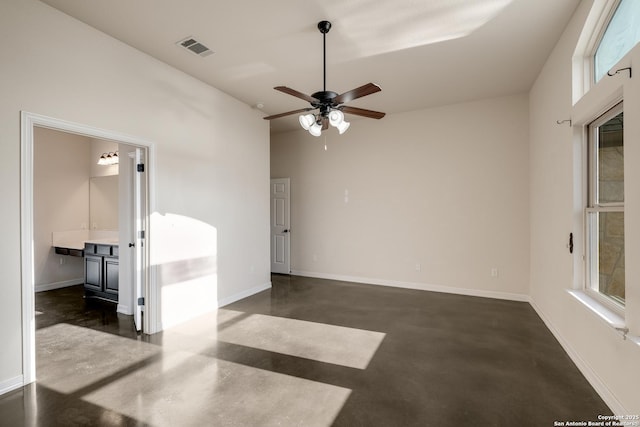 spare room featuring concrete flooring, visible vents, and baseboards