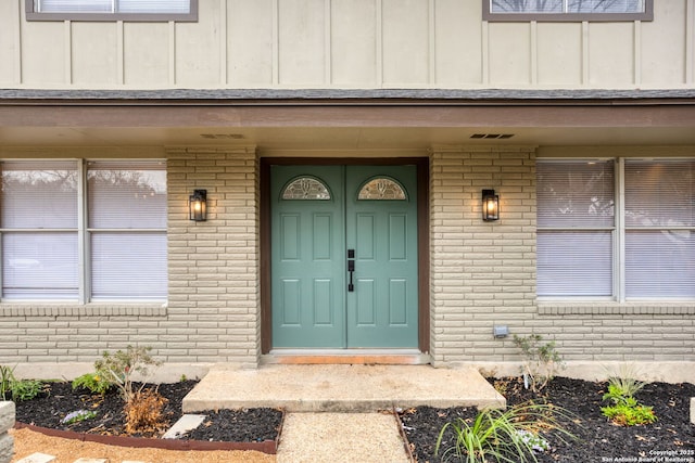 entrance to property featuring brick siding and board and batten siding