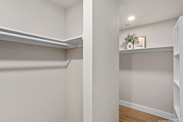 spacious closet featuring visible vents and wood finished floors