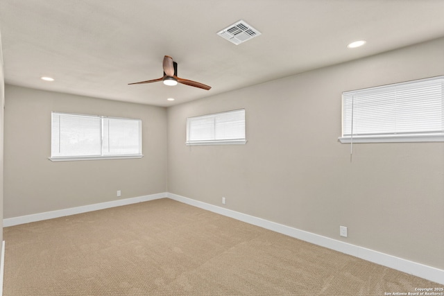 spare room with light carpet, recessed lighting, visible vents, and baseboards