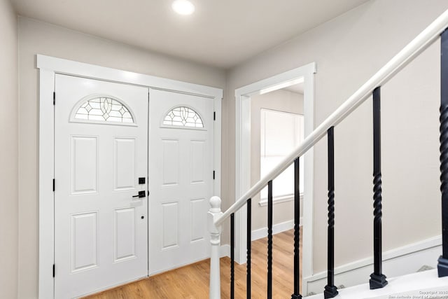 foyer with light wood finished floors and stairs