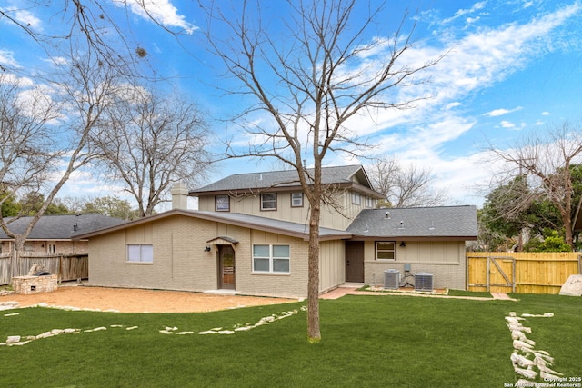 back of house with a yard, central AC, brick siding, and fence