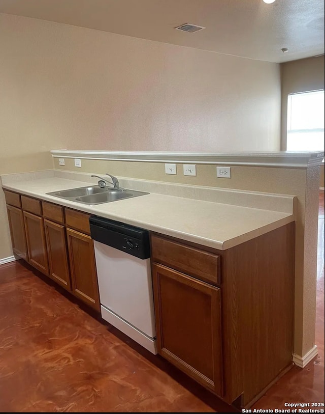 kitchen featuring brown cabinets, light countertops, visible vents, a sink, and dishwasher