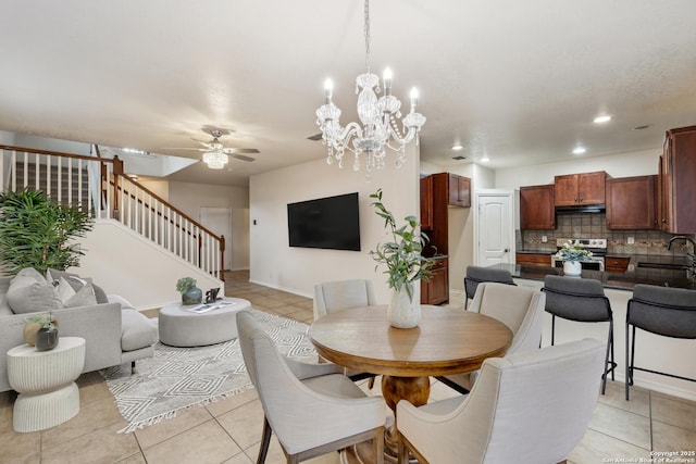 dining area featuring light tile patterned floors, recessed lighting, stairway, and ceiling fan with notable chandelier