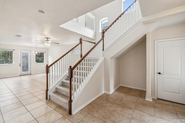 stairway featuring ceiling fan, visible vents, baseboards, and tile patterned floors