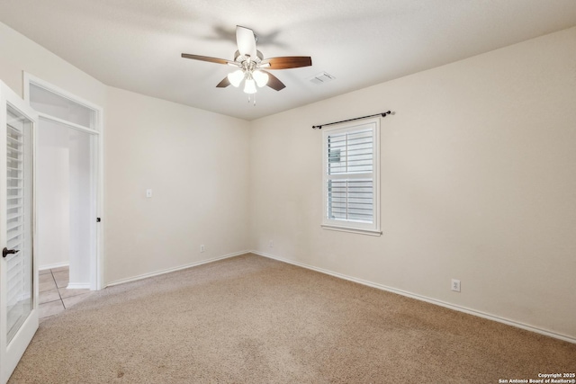 spare room featuring light carpet, baseboards, visible vents, and a ceiling fan