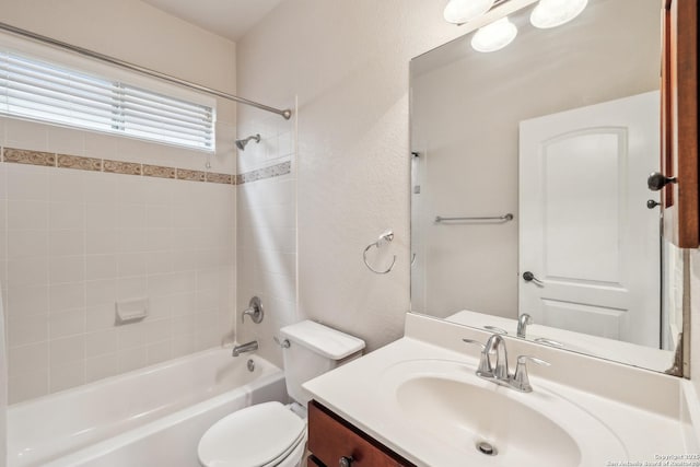 full bath with a textured wall, shower / tub combination, vanity, and toilet