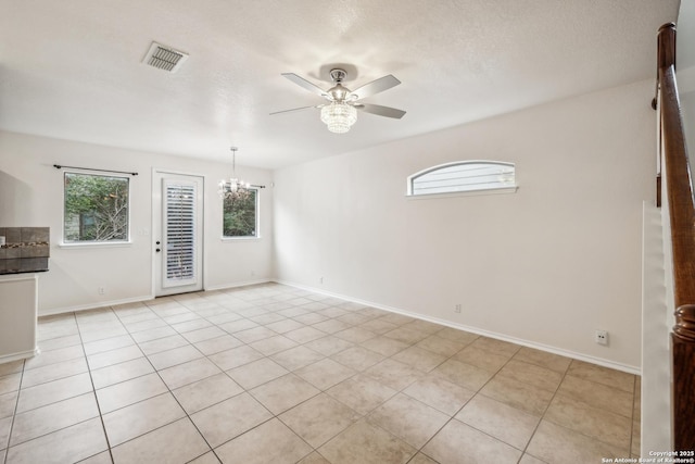 unfurnished room with a healthy amount of sunlight, baseboards, visible vents, and ceiling fan with notable chandelier