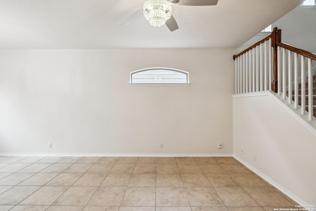 spare room with a ceiling fan, light tile patterned floors, baseboards, and stairs