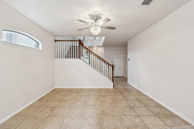 unfurnished room featuring light tile patterned flooring, visible vents, baseboards, a ceiling fan, and stairway