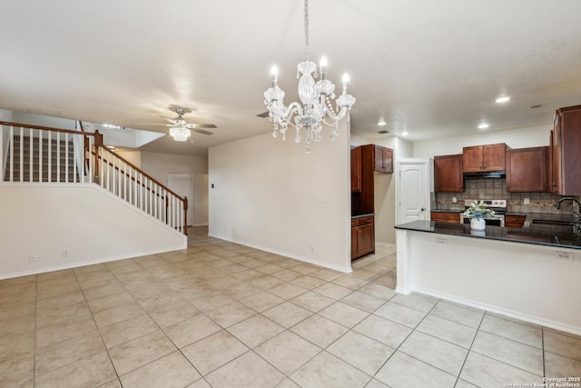 kitchen featuring electric stove, dark countertops, under cabinet range hood, backsplash, and ceiling fan with notable chandelier