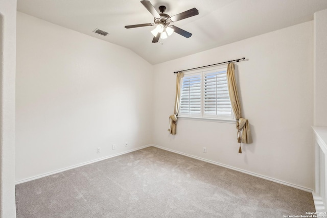 empty room with lofted ceiling, visible vents, a ceiling fan, carpet flooring, and baseboards