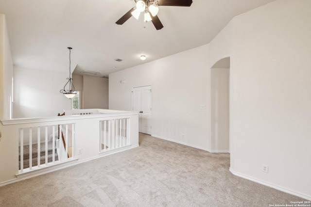 carpeted empty room with arched walkways and baseboards