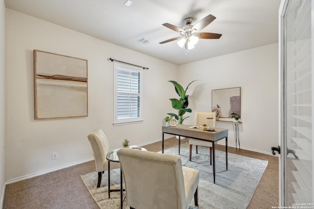 carpeted office space featuring visible vents, ceiling fan, and baseboards