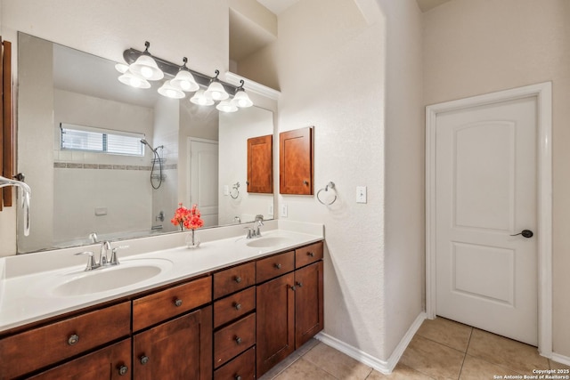 bathroom featuring double vanity, tile patterned flooring, a sink, and baseboards