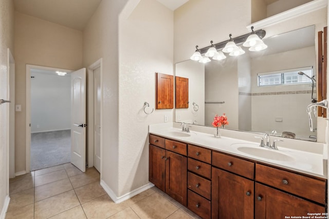 bathroom featuring a tile shower, double vanity, a sink, and tile patterned floors