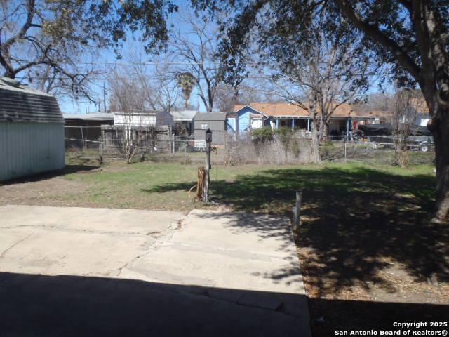 view of yard with a shed, an outdoor structure, and fence