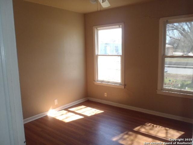 empty room featuring a ceiling fan, baseboards, and wood finished floors